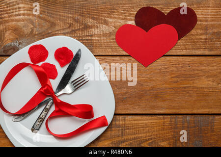 Il nastro nella piastra su sfondo di legno con un cuore Foto Stock