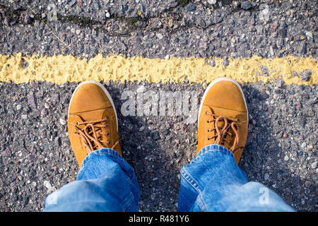Vista superiore del maschio di sneakers sulla strada asfaltata Foto Stock