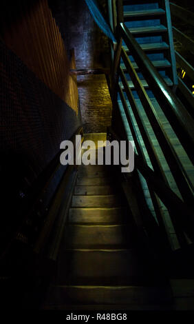 Un vecchio pericolosi scala in legno conduce al buio dungeon Foto Stock