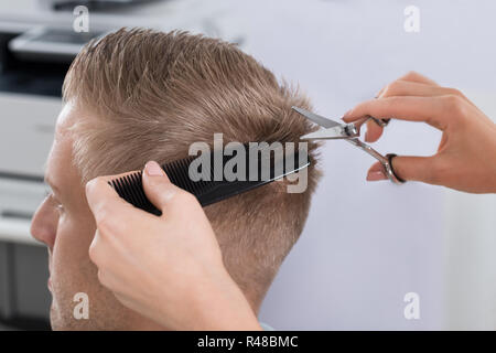 L'uomo Getting taglio di capelli da parrucchiere a Salon Foto Stock