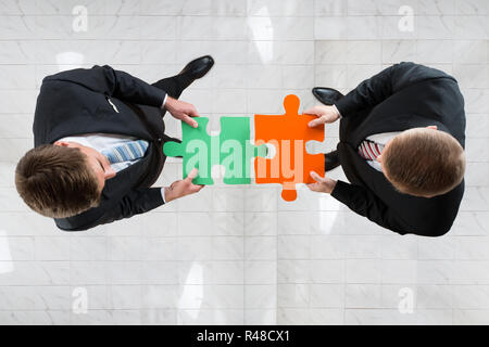 Imprenditori assemblaggio di Puzzle che rappresenta il lavoro di squadra Foto Stock