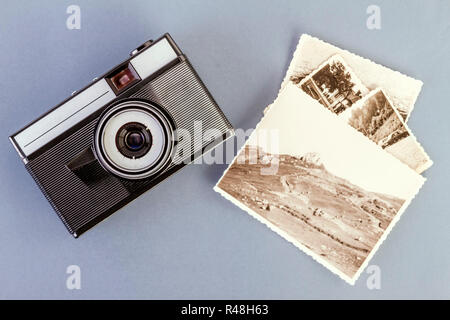 Vintage foto fotocamera e vecchie foto su una tabella di colore grigio Foto Stock