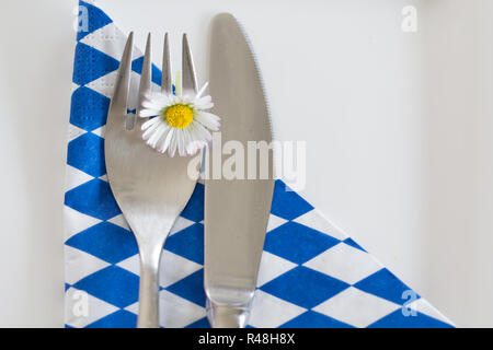 La cena è servita - cibo in Baviera! Una posata con margherite su un bianco-blu igienico Foto Stock