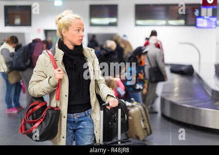 Viaggiatore femmina in attesa per i bagagli in aeroporto. Foto Stock