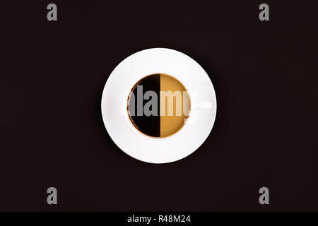 Una tazza da caffè con due diversi tipi di caffè in essa su sfondo scuro Foto Stock