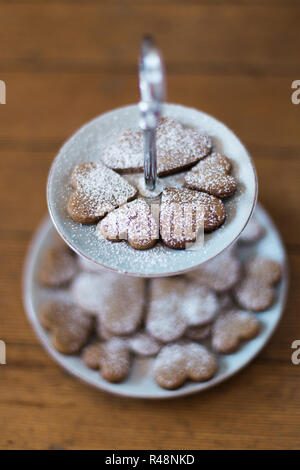 Alcuni a forma di cuore i cookie su una piastra di cookie Foto Stock