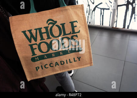 Dettaglio di un supermercato Whole Foods Market Hessian shopping bag essendo portato in un negozio di Piccadilly, Londra Foto Stock