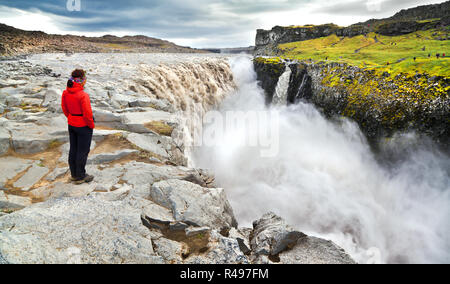 Vista panoramica della donna in piedi vicino la famosa cascata di Dettifoss in Vatnajokull National Park, Nord-est Islanda Foto Stock