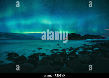 Incredibile Aurora Boreale ballare sulla famosa spiaggia di Uttakleiv durante una fredda notte artica sulle Isole Lofoten arcipelago in inverno, Norvegia e Scandinavia Foto Stock