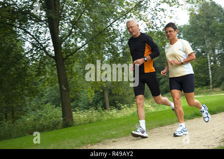 Coppia senior in esecuzione nei boschi Foto Stock