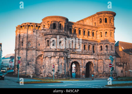 Celebre Porta Nigra, la più grande città romana monumento di gate a nord delle Alpi, nella splendida golden. La luce del mattino al sorgere del sole, città di Trier, Germania Foto Stock