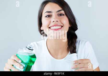 Bella ragazza usando un collutorio. Isolato su bianco. Foto Stock