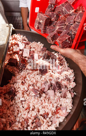 Taglierina per la macinazione di carne. Salsiccia della linea di produzione. Processo di fabbricazione di salsiccia Foto Stock