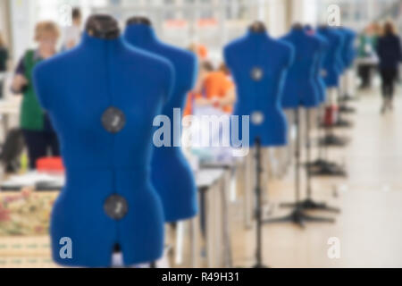 Sfocare lo sfondo con le donne sono impegnati nella sartoria di collant in una fabbrica Foto Stock