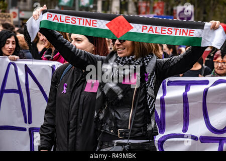 Una donna visto che mostra una sciarpa in solidarietà con le donne palestinesi durante la dimostrazione. Migliaia di persone sono scese in piazza a Barcellona in occasione della Giornata Internazionale per lâ eliminazione della violenza contro le donne. Foto Stock