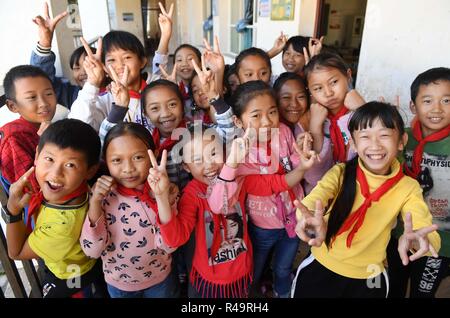 (181126) -- KUNMING, nov. 26, 2018 (Xinhua) -- Gli studenti pongono per le foto all'etnico scuola primaria in Jino Township etniche sulla montagna Jino a Jinghong di Xishuangbanna Dai prefettura autonoma, a sud-ovest della Cina di Provincia di Yunnan, nov. 20, 2018. La maggior parte dei 712 studenti iscritti a scuola sono di etnia Jino discesa. Con una popolazione di poco più di 20.000, il popolo Jino aveva solo stato ufficialmente riconosciuto nel 1979 come un autonomo gruppo etnico della Cina. Fino al 1949, la maggior parte di essi aveva vissuto per generazioni nella primitiva tribù di montagna nel sud-ovest della Cina di Provincia di Yunnan. Foto Stock