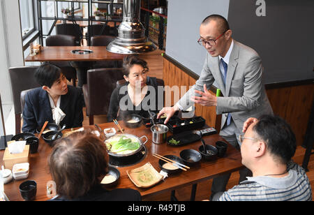 (181126) -- NANJING, nov. 26, 2018 (Xinhua) - Giapponese Kazuhiro Tozawa introduce la cucina giapponese per i clienti presso il suo ristorante barbecue in Xinjiekou di Nanjing, a est della capitale cinese della provincia di Jiangsu, 16 ottobre 2018. Kazuhiro Tozawa, 45, gestisce un ristorante barbecue in Xinjiekou di Nanjing. Egli è venuto a Nanchino nel 1996 per saperne di medicina tradizionale cinese per curare la propria malattia. Avendo soggiornato in Nanjing per 22 anni, Kazuhiro Tozawa ama la città e rende molti amici qui. Egli considera Nanjing come suo "hometown', dove rimarrà per il resto della sua vita. (Xinhua/Ji Chunpeng) (zwx) Foto Stock