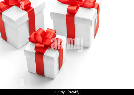 Tre confezioni regalo con nastri di colore rosso su sfondo bianco Foto Stock