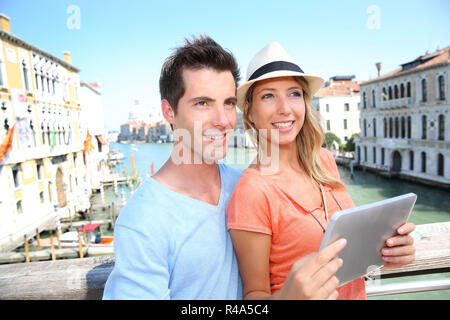 Paio utilizzando tablet sul Ponte dell'Accademia di Venezia, Italia Foto Stock