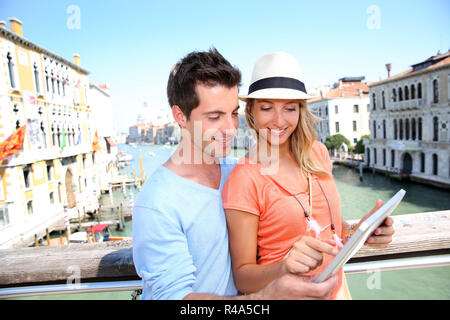 Paio utilizzando tablet sul Ponte dell'Accademia di Venezia, Italia Foto Stock