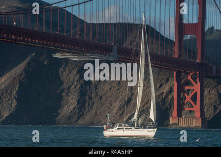 Una barca a vela passa di fronte al Golden Gate bridge nella Baia di San Francisco. Foto Stock