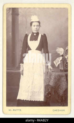 Originale Victorian carte de Visite (CDV) di housemaid, indossando un grembiule bianco e un cappuccio, blusa con 'maniche italiane' alla moda W. Butts studio, Chesham, Buckinghamshire, Regno Unito circa 1890, 1891 Foto Stock