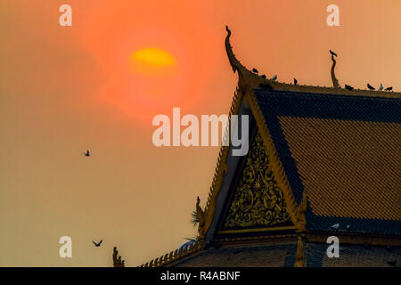 Tramonto dietro ornano il tetto dell'edificio nel Palazzo Reale complesso; Royal Palace e Centro della città di Phnom Penh Foto Stock