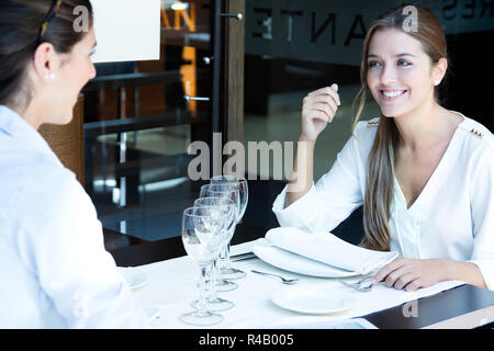 Due business sorridente le donne hanno la cena al ristorante Foto Stock