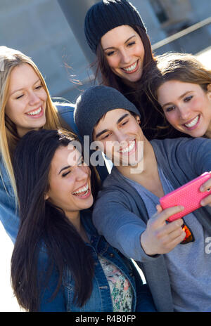 Un gruppo di amici per scattare delle foto con uno smartphone Foto Stock