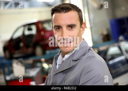 Ritratto del carrozziere in piedi in autoshop Foto Stock