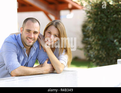 Allegro giovane in piedi di fronte a casa Foto Stock