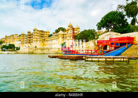 Barca tradizionale di fronte Palazzo di Città complessa, Udaipur, Rajasthan, India Foto Stock