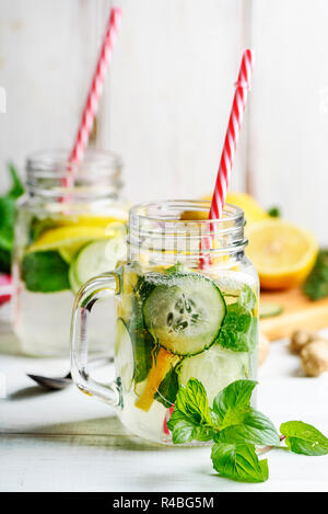 Detox drink con acqua, il cetriolo, la limonata e menta in mason vasetto di vetro con cannucce retrò. Foto Stock