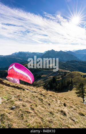 Einsiedeln, SZ / Svizzera - Novembre 25, 2018: uomo con parapendio preparando per decollare da un elevato picco di montagna durante un corso per istruttore Foto Stock