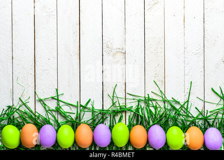 Felice Pasqua uova su sfondo di legno, uova colorate su lavagne bianche Foto Stock