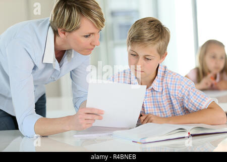 Insegnante che mostra la carta per alunno in classe Foto Stock