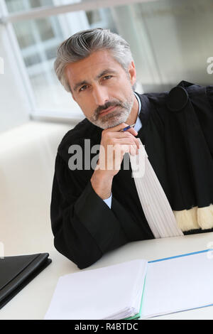Avvocato maturo lavorando sulla relazione di giudizio Foto Stock