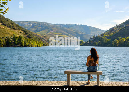 Pinhao, Portogallo - 05 Ottobre 2018 : Donna ammirando il bellissimo paesaggio sulle rive del fiume Douro, Vila Real, Portogallo Foto Stock