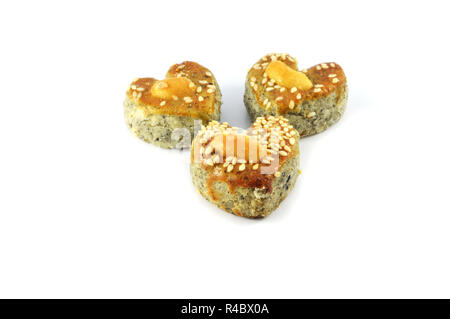 Mini cookies isolato / a forma di cuore di cookies torta con sesamo bianco e anacardi sulla cima isolata su sfondo bianco Foto Stock