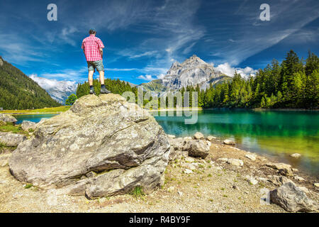 L'uomo gode di vista di Arnisee con Alpi Svizzere. Arnisee è un serbatoio nel Cantone di Uri, Svizzera, Europa. Foto Stock