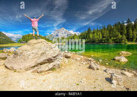 L'uomo gode di vista di Arnisee con Alpi Svizzere. Arnisee è un serbatoio nel Cantone di Uri, Svizzera, Europa. Foto Stock