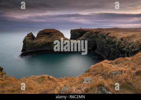 Scogliere vulcaniche e rocce basaltiche che in Arnarstapi, Islanda Foto Stock