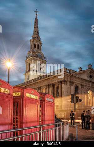 Westminster, Londra- St Martin-in-Campi Chiesa e cabine telefoniche rosse shot dal filamento uscita di Charing Cross stazione della metropolitana Foto Stock
