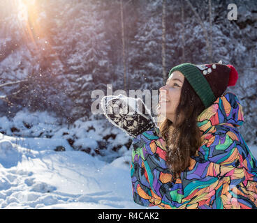 Ragazza di Natale ritratto all'aperto. Inverno donna soffiando la neve in un parco Foto Stock