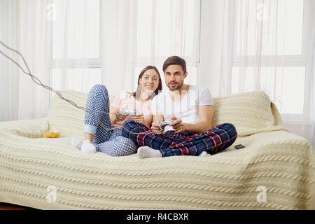 Marito e moglie si riproduce il video giochi con joystick in mani in th Foto Stock