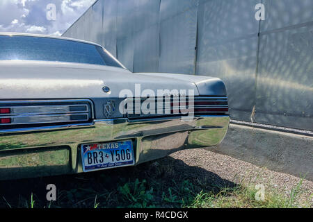 Un vintage Buick si siede molto vicino a una parete di lamiera in Marfa. Foto Stock
