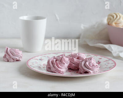 Tazza da caffè con rosa marshmallows su uno sfondo luminoso Foto Stock