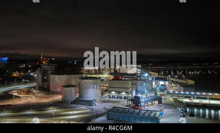 Moderno terminale di grano di notte. Serbatoi in metallo di ascensore. Granella di essiccazione di costruzione complessa. Grani commerciale di sementi o silos a Seaport. Storage di acciaio per il raccolto agricolo. Foto Stock