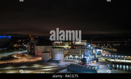 Moderno terminale di grano di notte. Serbatoi in metallo di ascensore. Granella di essiccazione di costruzione complessa. Grani commerciale di sementi o silos a Seaport. Storage di acciaio per il raccolto agricolo. Foto Stock