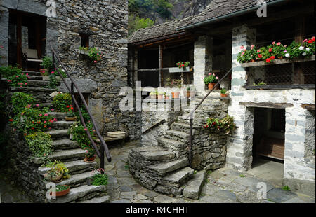 Scale di roccia e le tradizionali case in pietra a townsquare nel vecchio villaggio Sonlerto, Val Bavona, Tcicino, Svizzera Foto Stock